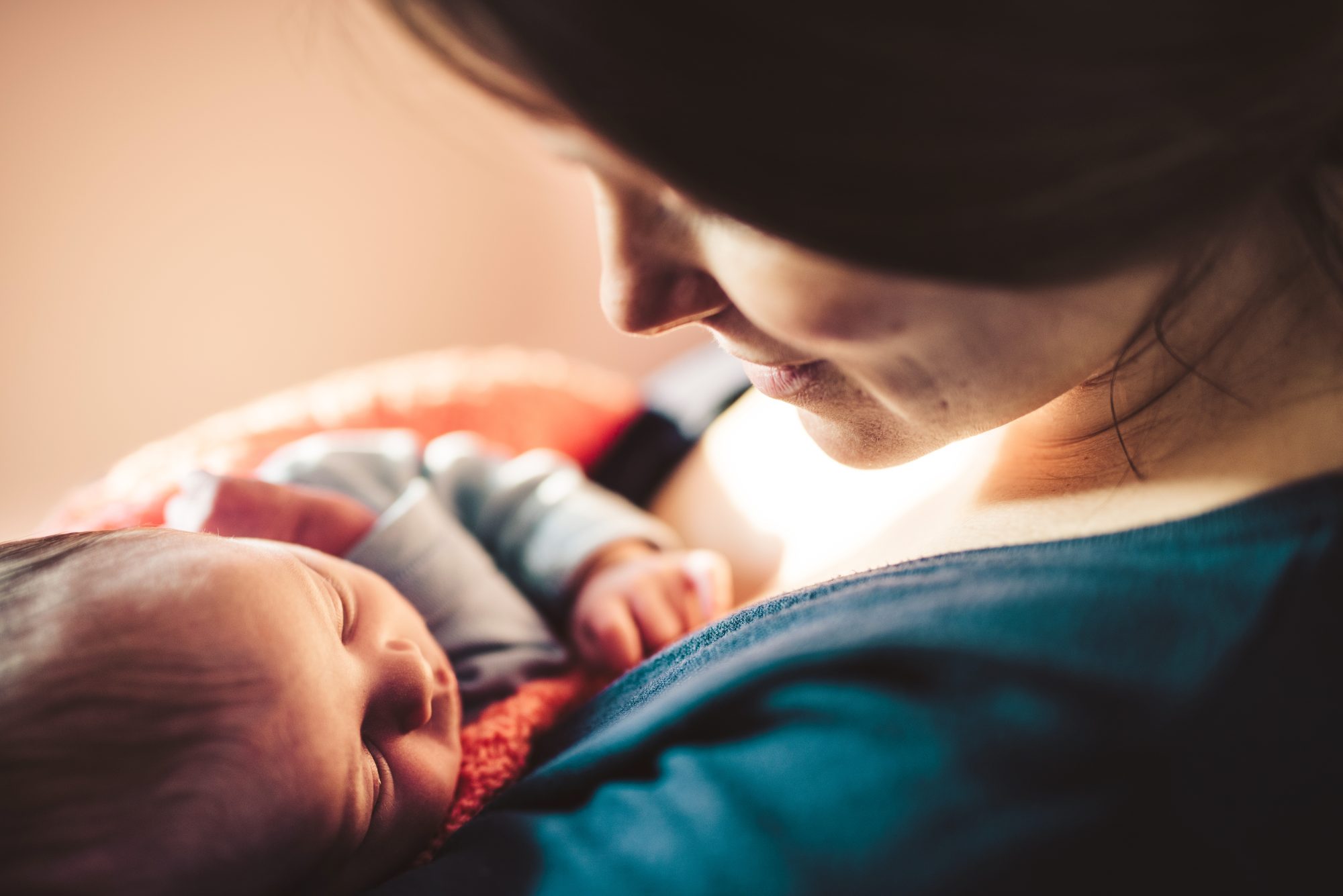 side view of smiling mother looking at her newborn baby