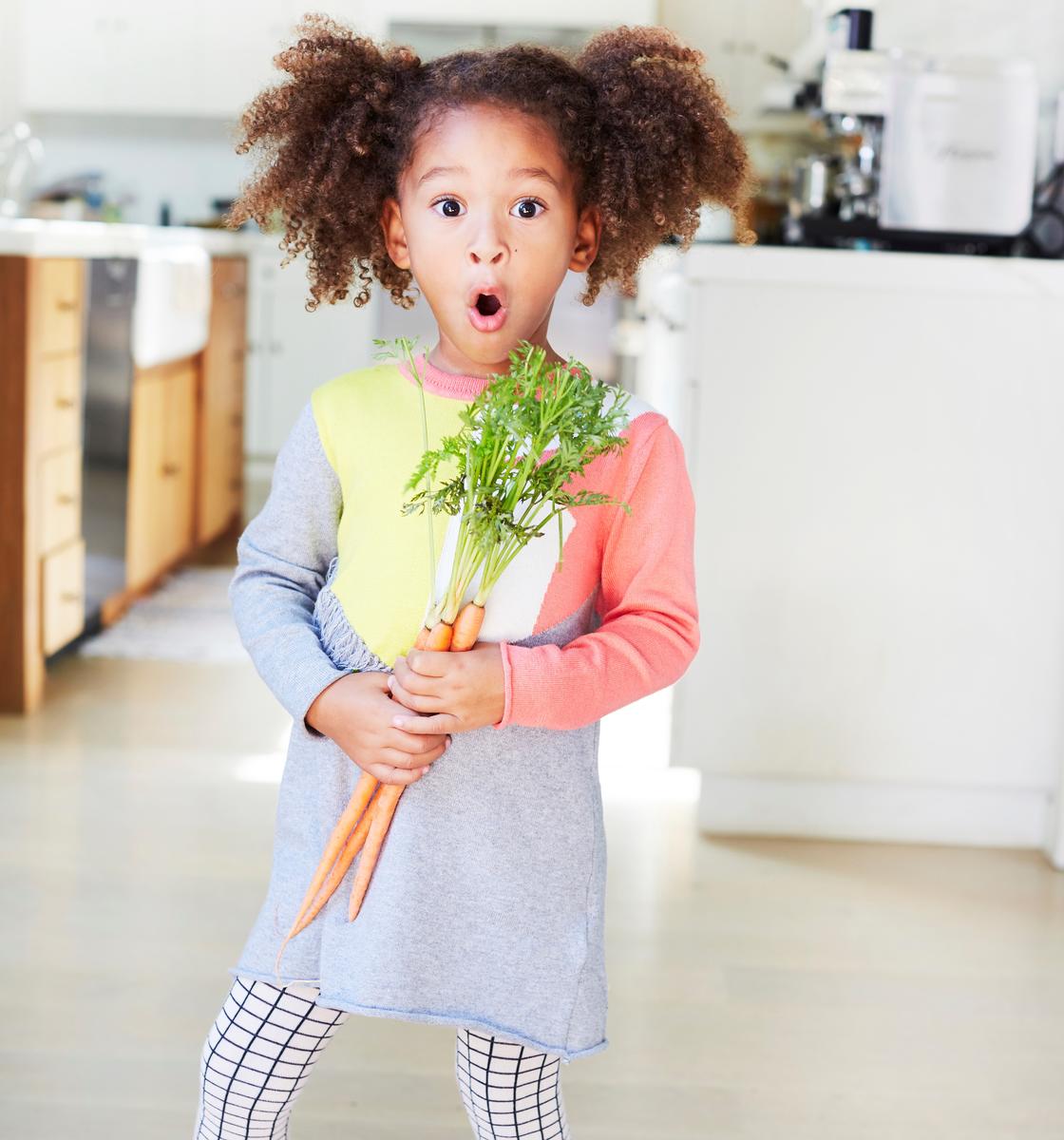 Little Girl Curly Hair Holding a Carrot