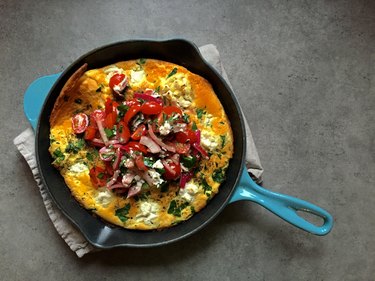 Savoury Dutch baby pancake in cast iron skillet, tomato salad