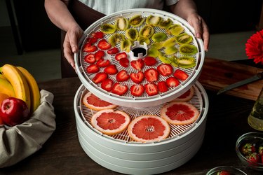 Stacking dehydrator trays with sliced fruits