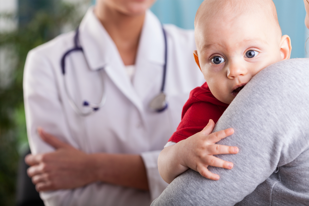 mom holding baby in doctor's office