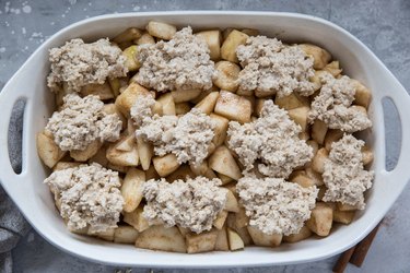 Casserole dish with spiced pears and cobbler topping, ready to go in the oven.