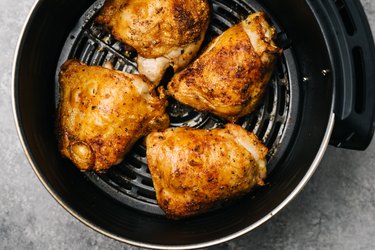 Four spicy air fried chicken thighs in an air fryer