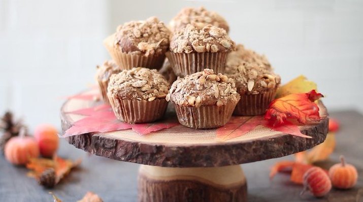 Pumpkin spice latte muffins mounded on a cake server made from a live-edge slice from a tree trunk