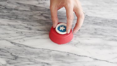 Placing fondant shapes on top of chocolate covered Oreo