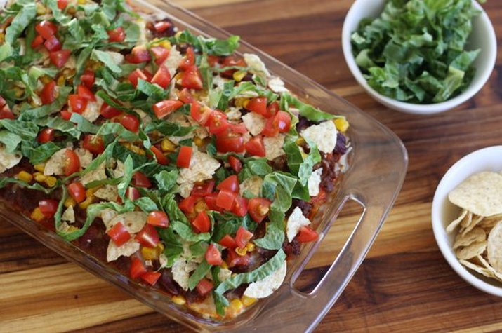 Taco casserole served with tortilla chips and extra garnish