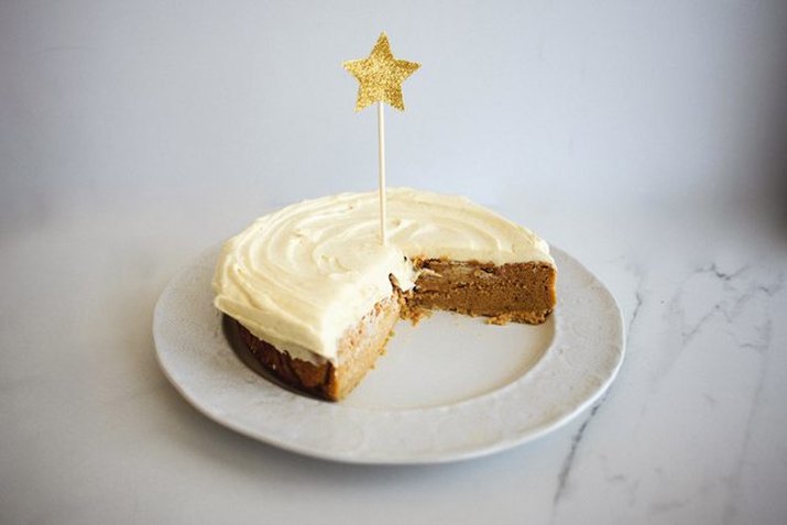 A pumpkin pie magic cake on a white plate with a quarter missing