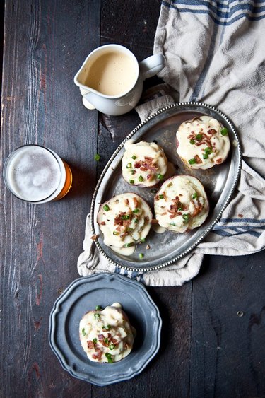 Baked beer cheese potatoes garnished with bacon crisps and scallions.